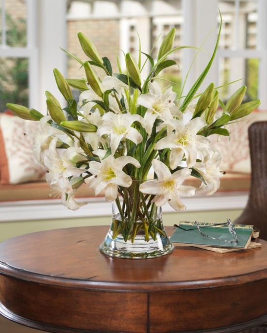 Ιδέες διακόσμησης καλοκαιρινών λουλουδιών λευκά κρίνα απερίγραπτα όμορφα σε ένα βάζο στο τραπεζάκι του καφέ