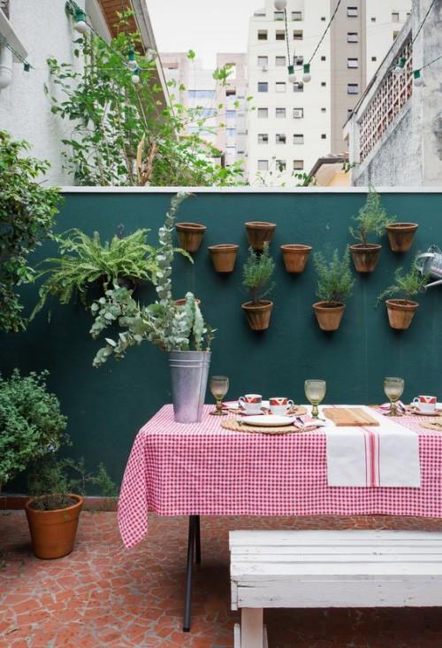 Καλοκαιρινό πάρτι μικρού δωματίου μεγάλη πόλη διακοσμημένο τραπέζι φαγητού κρεμασμένες γλάστρες