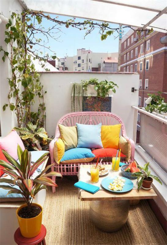 Η βεράντα είναι έτοιμη για την άνοιξη, δημιουργώντας ένα μικρό μπαλκόνι, μικρούς καναπέδες, ένα στρογγυλό τραπέζι, πολλά λουλούδια, πολύχρωμα μαξιλάρια, μια ανοιξιάτικη ατμόσφαιρα