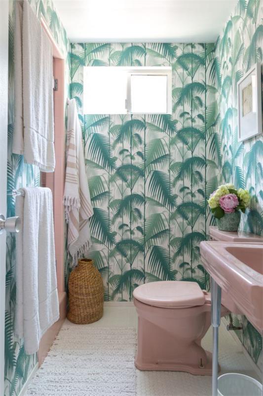 Τροπική διακόσμηση στο μπάνιο εξωτικά τροπικά φύλλα ταπετσαρία πολλές πράσινες πετσέτες τουαλέτας νιπτήρα σε ροζ καλό συνδυασμένο καλάθι λευκό δρομέα