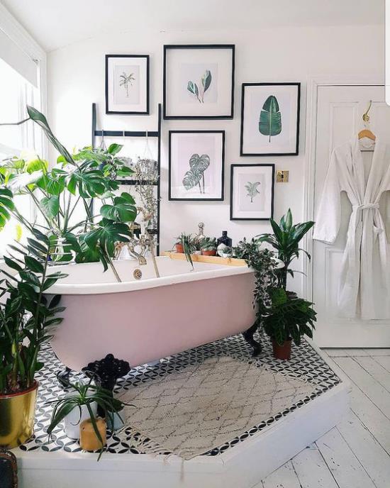 Τροπική διακόσμηση στο μπάνιο ανεξάρτητη μπανιέρα με νύχια που περιβάλλεται από χαιρετισμούς γλάστρες διακόσμηση τοίχου τοίχων εικόνες μεγάλα εξωτικά φύλλα