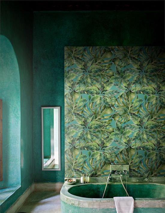 Τροπική διακόσμηση στο μπάνιο πράσινοι τοίχοι ταπετσαρία εξωτικά φύλλα ενσωματωμένος καθρέφτης τοίχου μπανιέρας στο παράθυρο φόντου αριστερά
