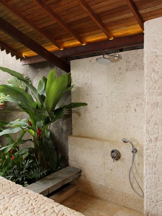 Τροπική διακόσμηση στο μπάνιο καταπράσινα φυτά μεγάλα φύλλα πολλά φυσική πέτρα ξύλο ωραία ατμόσφαιρα