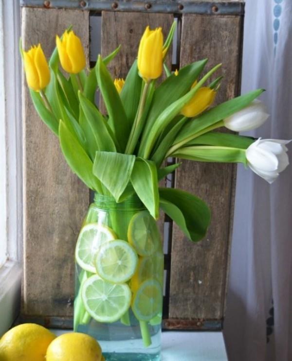 Τουλίπες στο εσωτερικό κίτρινα και άσπρα λουλούδια στο ποτήρι με φέτες λεμονιού