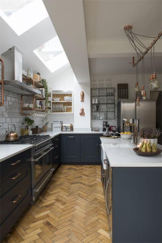 Η U-κουζίνα ταιριάζει στο χώρο κάτω από το κεκλιμένο φεγγίτη της οροφής με ενδιαφέρον σχεδιασμό δωματίου