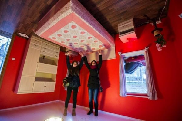 Ανάποδο σπίτι στη Ρωσία κόκκινο τοίχο κρεβάτι στην ντουλάπα