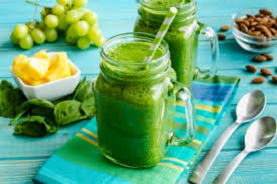 Mason γυάλινη κούπα γεμάτη με πράσινο λάχανο σπανάκι πιείτε σταφύλια πράσινα smoothies μπλε ριγέ χαρτοπετσέτα