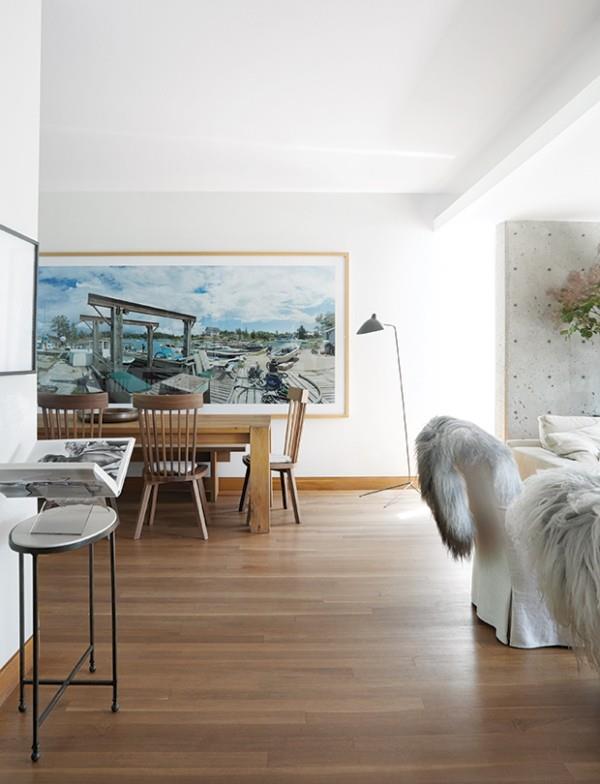Λευκό σαλόνι και τραπεζαρία με πολλές ξύλινες ζωγραφιές στον τοίχο