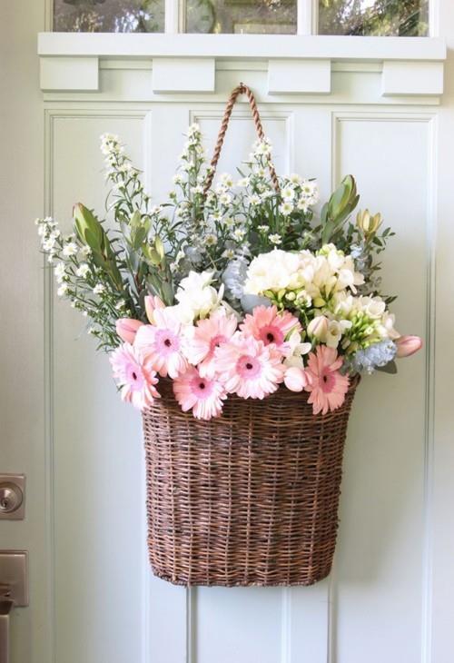 Ickάθινο καλάθι γεμάτο όμορφα λουλούδια στην πόρτα