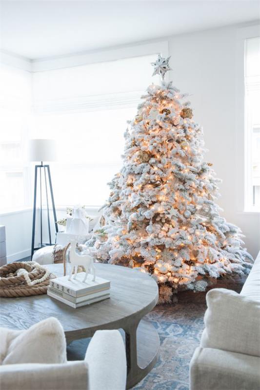 Χριστουγεννιάτικο δέντρο στολίζει σε λευκό και ασημί όμορφα διακοσμημένο χριστουγεννιάτικο δέντρο όλα τα φώτα αναμμένα.