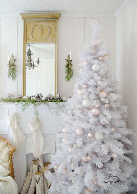 Χριστουγεννιάτικο δέντρο στολίζει σε λευκό και ασημί όμορφη θέα μπροστά από το τζάκι όλο σε λευκό