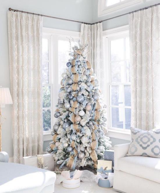 Χριστουγεννιάτικο δέντρο στολίζει σε λευκό και ασημί λευκό περιβάλλον διακοσμημένο χριστουγεννιάτικο δέντρο εντυπωσιακά δώρα από κάτω
