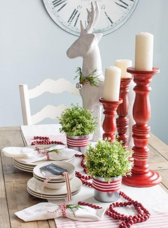 Χριστουγεννιάτικες ιδέες διακόσμησης σε κόκκινο και άσπρο στρωμένο τραπέζι λευκά πιάτα κόκκινο κηροπήγιο