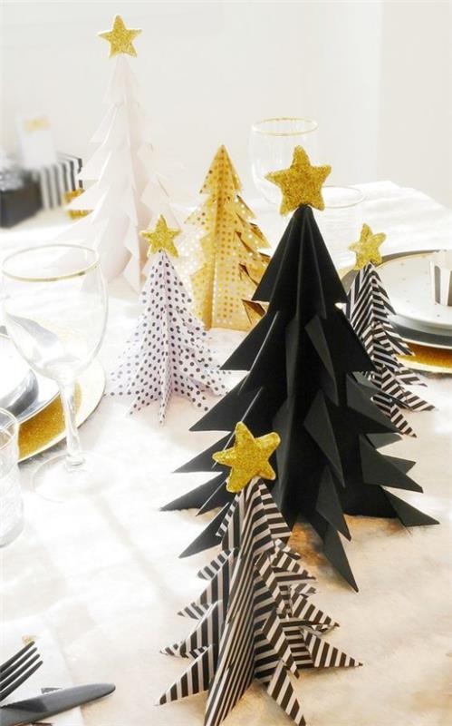 Χριστουγεννιάτικα στολίδια σε χρυσό και μαύρο διακοσμητικό εορταστικό τραπέζι, μικρά έλατα σε μαύρο χρώμα με χρυσές πινελιές, ριγέ ή διακεκομμένα