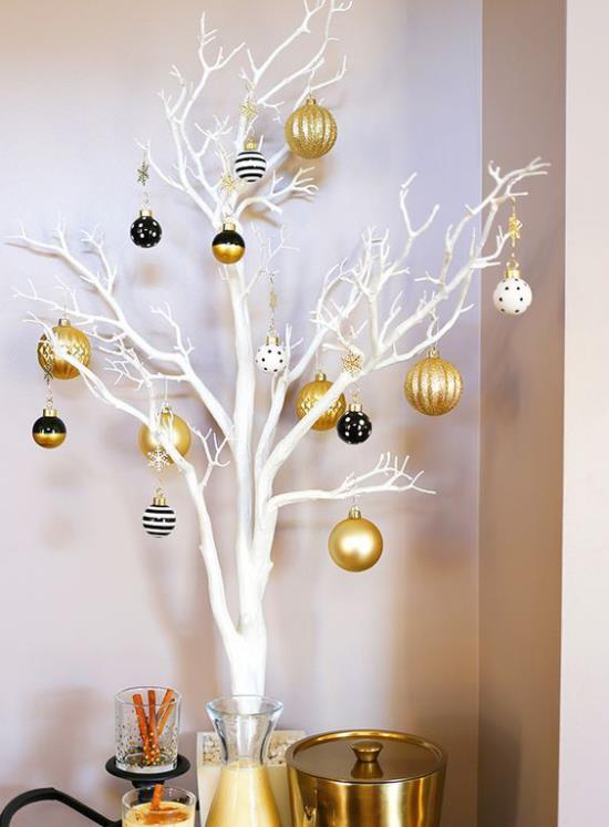 Χριστουγεννιάτικα στολίδια σε χρυσό και μαύρο, λευκά κλαδιά, χρυσοκίτρινες μπάλες ως μικρές μαύρες πινελιές