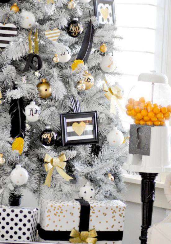 Χριστουγεννιάτικα στολίδια σε χρυσό και μαύρο Λευκό χριστουγεννιάτικο δέντρο τυλιγμένο με δώρα, συμπεριλαμβανομένων μεμονωμένων τόνων σε χρυσό και μαύρο