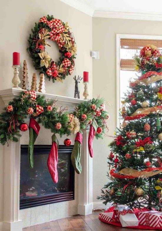 Χριστουγεννιάτικα στολίδια σε κόκκινο και χρυσό Χριστουγεννιάτικο δέντρο τζάκι γιρλάντα Άγιος Βασίλης μπότες κόκκινα κεριά μικρά έλατα από ξύλο