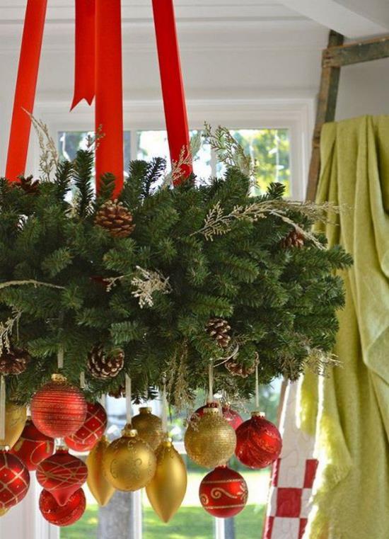 Χριστουγεννιάτικη διακόσμηση σε κόκκινο και χρυσό Πλούσια χριστουγεννιάτικη διακόσμηση κρέμεται από τον πολυέλαιο, πολλά μενταγιόν από πράσινα κουκουνάρια.