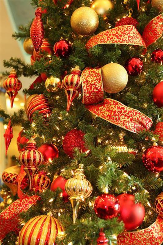 Χριστουγεννιάτικα στολίδια σε κόκκινο και χρυσό όμορφη χριστουγεννιάτικη διακόσμηση χριστουγεννιάτικων δέντρων μεγάλα τόξα μπάλες μενταγιόν γιρλάντες χρυσές πινελιές