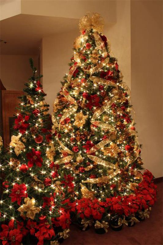 Χριστουγεννιάτικα στολίδια σε κόκκινο και χρυσό, δύο χριστουγεννιάτικα δέντρα το ένα δίπλα στο άλλο λαμπερά διακοσμημένα