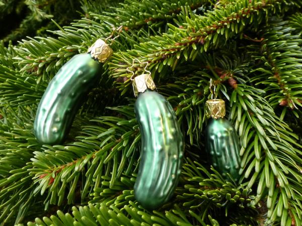 Χριστουγεννιάτικα στολίδια πράσινου γυαλιού αγγουριού σε σχήμα αγγουριού κρυμμένα ανάμεσα στα κλαδιά του έλατου