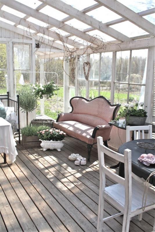 Χειμερινός κήπος για να κολλήσει μέχρι το ροζ καναπέ -τραπέζι πράσινα γλάστρες φυτά απλή επίπλωση ευχάριστη ατμόσφαιρα