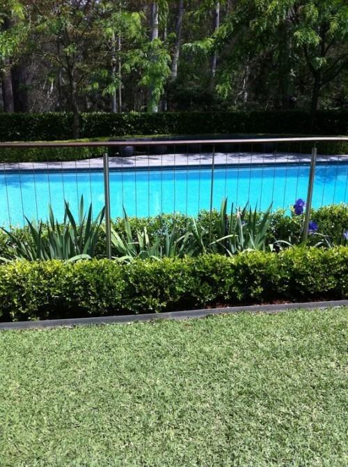 Φράχτη γύρω από ιδέες πισίνας κατασκευασμένες από μέταλλο με πολυάριθμα πράσινα φυτά