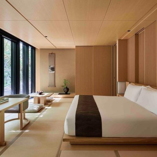 Μινιμαλισμός Zen υπνοδωματίου σε ιαπωνικό άνετο κρεβάτι μεγάλο παράθυρο πολλά ξύλινα μπεζ σειρά και καθαριότητα