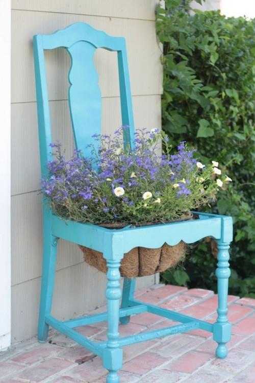 παλιά καρέκλα σε μπλε βαμμένη γλάστρα στη μέση της διακόσμησης του κήπου