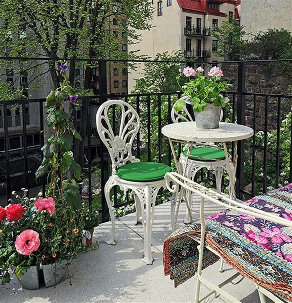 ελκυστικός κήπος σε μπαλκόνι λουλούδια μεταλλικά έπιπλα