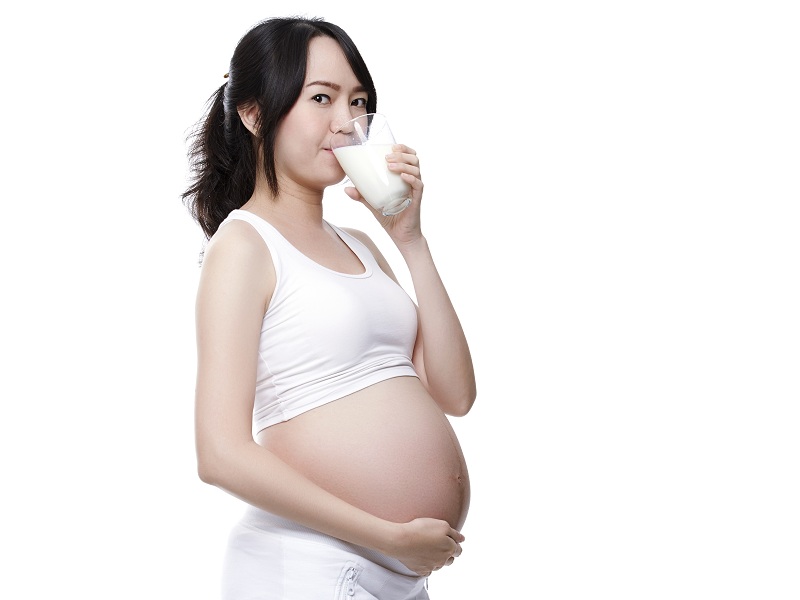 Nėščia moteris geria pieną
