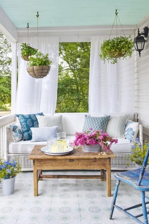 Σκεπαστή βεράντα σε μπλε και λευκό, σαν ένας μικρός κήπος, κρεμασμένα κρεμαστά καλάθια
