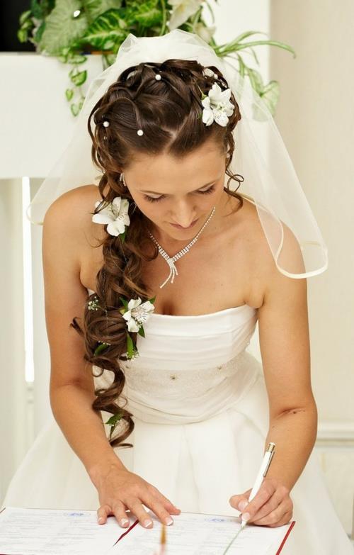 γαμήλια χτενίσματα με λουλούδια ευαίσθητα λευκά λουλούδια σκούρες μπούκλες