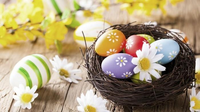 Διακόσμηση πολύχρωμων πασχαλινών αυγών με λουλούδια σε φωλιά ιτιάς