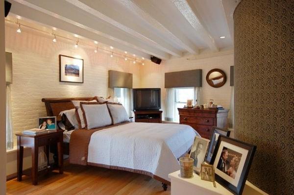 Αποικιακά κρεβάτια στο κομψό υπνοδωμάτιο με φώτα πίστας
