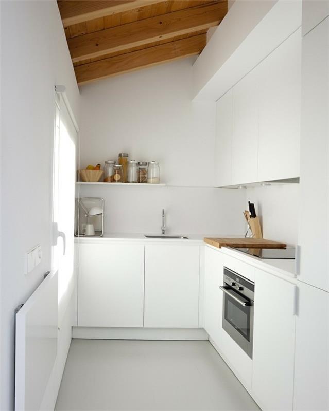 Η κεκλιμένη στέγη στήνει τη λευκή μινιμαλιστική κουζίνα