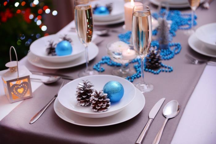 εορταστική διακόσμηση τραπεζιού Χριστουγεννιάτικες μπλε πινελιές κουκουνάρια στο πιάτο