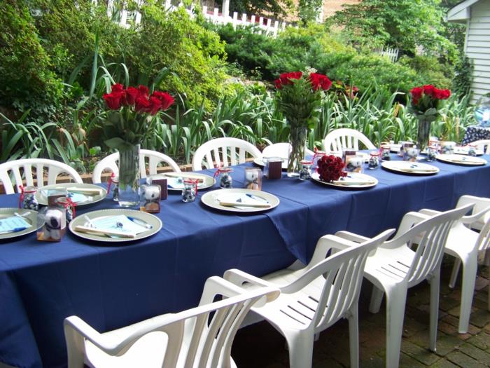 εορταστικές διακοσμήσεις τραπεζιού μπλε τραπεζομάντηλο κόκκινα τριαντάφυλλα λευκές καρέκλες