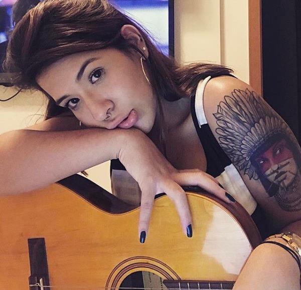 γυναίκα με ινδικό τατουάζ κιθάρας