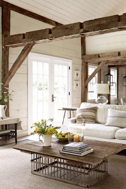 εκτεθειμένα δοκάρια ξύλινο τραπέζι λευκά έπιπλα ζεστό σαλόνι σε στυλ εξοχικής κατοικίας