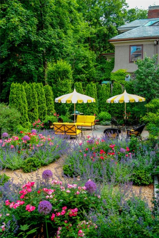 φρέσκα χρώματα στον κήπο πολύχρωμα λουλούδια λεμόνι κίτρινα έπιπλα κήπου και ομπρέλες