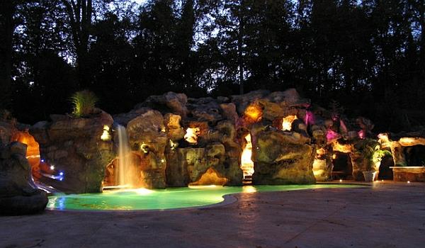 κήπος με φωτισμό καταρράκτη πισίνας τη νύχτα