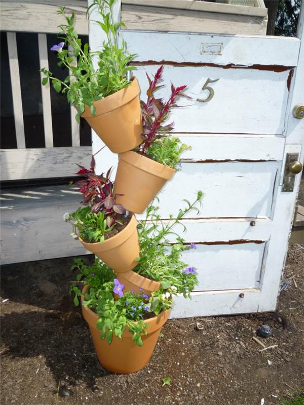 διακόσμηση κήπου με βερνίκι, τακτοποιήστε γλάστρες με φυτά το ένα πάνω στο άλλο