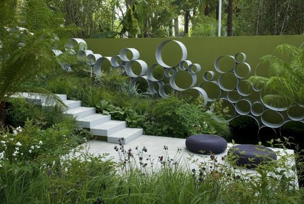 ιδέες κήπου τσιμεντένια πλακάκια μαξιλάρια καθισμάτων μεταλλική διακόσμηση σκαλοπάτια καλοκαιρινά φυτά βεράντα