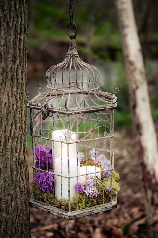 ιδέες διακόσμησης πάρτι κήπου boho chic στυλ deco παλιό κλουβί λευκά κεριά λιλά βρύα