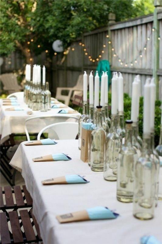 πάρτι κήπου εξωτερική διακόσμηση τραπεζιού γυάλινα μπουκάλια λευκά κεριά