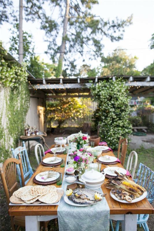 τραπέζι πάρτι κήπου με φρέσκα λουλούδια vintage καρέκλες