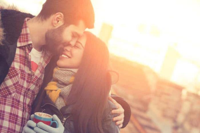 μείνετε υγιείς και ευτυχισμένοι το χειμώνα το νεαρό ζευγάρι αγκαλιάζει τα γέλια παρά το κρύο