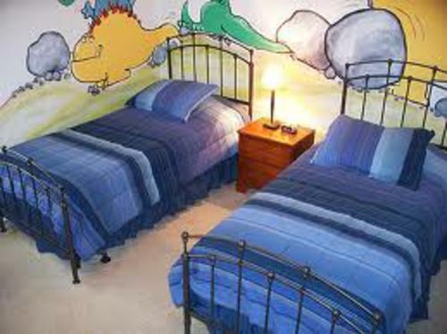 πανέμορφο σχέδιο παιδικού δωματίου δύο παιδικές ζωγραφιές σε μπλε τοίχο