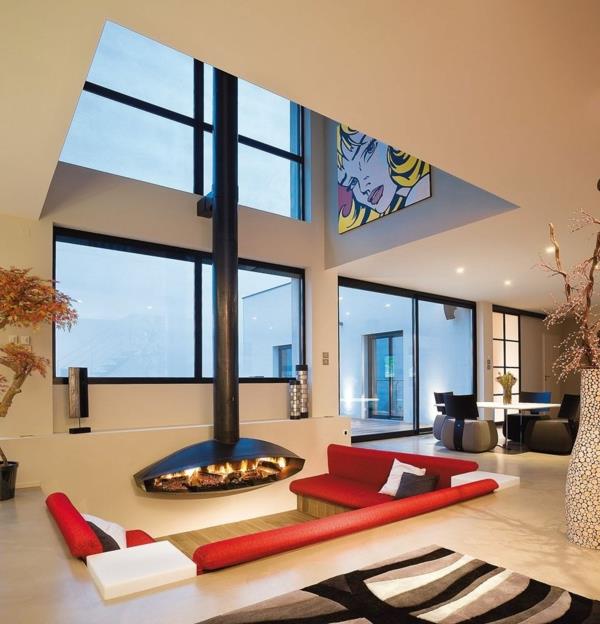 κρεμαστό τζάκι σε μοντέρνο σπίτι κόκκινους καναπέδες χαλί τοίχους από γυαλί